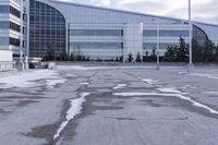 a street sign is sitting in the middle of an empty parking lot outside a building