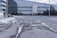 a street sign is sitting in the middle of an empty parking lot outside a building