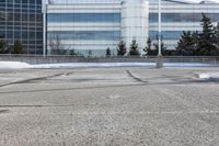 a street sign is sitting in the middle of an empty parking lot outside a building