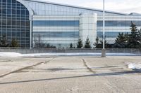 a street sign is sitting in the middle of an empty parking lot outside a building