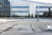 a street sign is sitting in the middle of an empty parking lot outside a building