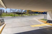 a empty car park with yellow signs posted for use by people in the area behind