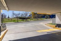 a empty car park with yellow signs posted for use by people in the area behind