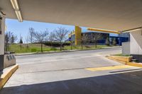 a empty car park with yellow signs posted for use by people in the area behind