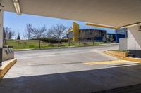 a empty car park with yellow signs posted for use by people in the area behind