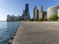 a group of tall buildings sit on the water's edge, in this photograph