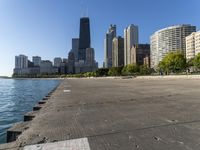 a group of tall buildings sit on the water's edge, in this photograph