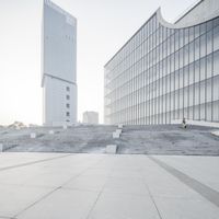 there is an empty concrete plaza outside the building, as well as a statue near by