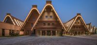 an unusual wooden building that is illuminated by led lights from the inside of the tower