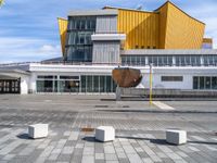 an open umbrella sits in front of the art museum at daytime, looking out across the courtyard