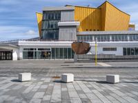 an open umbrella sits in front of the art museum at daytime, looking out across the courtyard