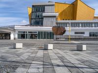 an open umbrella sits in front of the art museum at daytime, looking out across the courtyard