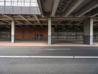 an empty parking garage with the doors closed in the center of it, next to a sidewalk