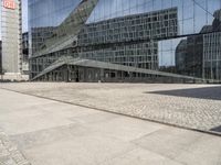 a building that has some stairs by it and is tall glass in front of the building