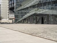 a building that has some stairs by it and is tall glass in front of the building