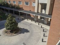 a group of people walking across a cement courtyard next to a brick building and walkway