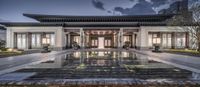 a view of the front entrance to an asian style building with reflection pool in the foreground