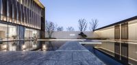 a reflection of the building on the water in a pool at dusk / / / via istelphut