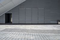 an open door in the corner of a gray building at the entrance to a parking garage