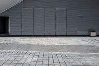 an open door in the corner of a gray building at the entrance to a parking garage