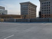 several large empty parking spaces in the city with buildings nearby in front of them -