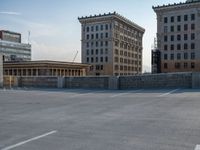 several large empty parking spaces in the city with buildings nearby in front of them -