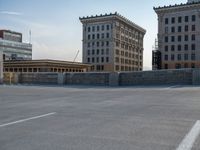 several large empty parking spaces in the city with buildings nearby in front of them -