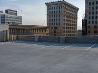 several large empty parking spaces in the city with buildings nearby in front of them -