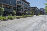 a street with several building in it, with people walking on the side walk and trees on both sides