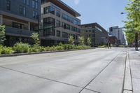 a street with several building in it, with people walking on the side walk and trees on both sides
