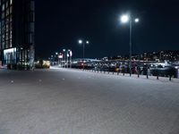 the scene in this picture is a city at night and a few people are walking