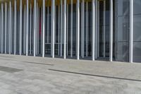 a building that has a large number of columns around it on the sidewalk outside of the room