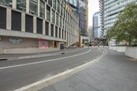 this is an empty street next to tall buildings in the city, as if they were walking out there