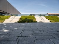 this is a view from outside the building of a stone walkway with steps leading to the front