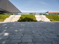 this is a view from outside the building of a stone walkway with steps leading to the front