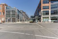 empty city street with buildings and street cars along side of it on clear day, in the middle of winter