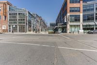 empty city street with buildings and street cars along side of it on clear day, in the middle of winter