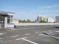 a empty parking lot in the middle of a large city with a view of a street