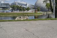 the scene has many buildings with a river behind them and a water fountain next to it