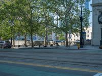 an empty street with buildings and parked cars on the sidewalks and green lanes on the sidewalk