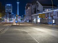 an empty street with no traffic on the night, and buildings in the background by night