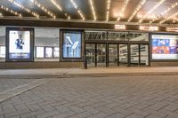 a street view of a hotel lobby and entrance with lit up front windows at night