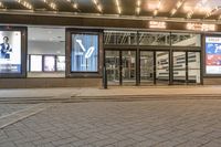 a street view of a hotel lobby and entrance with lit up front windows at night