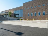 the empty street is lined with stairs leading to a brick building on a sunny day