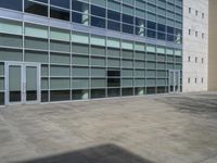 the concrete walkway has been paved with squares of tiles and glass in a courtyard in front of a building