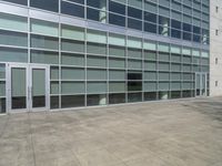 the concrete walkway has been paved with squares of tiles and glass in a courtyard in front of a building