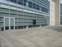 the concrete walkway has been paved with squares of tiles and glass in a courtyard in front of a building