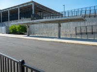 the concrete structure behind the gate is painted white and contains parking lots on both sides