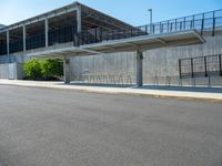 the concrete structure behind the gate is painted white and contains parking lots on both sides