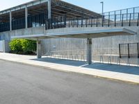 the concrete structure behind the gate is painted white and contains parking lots on both sides